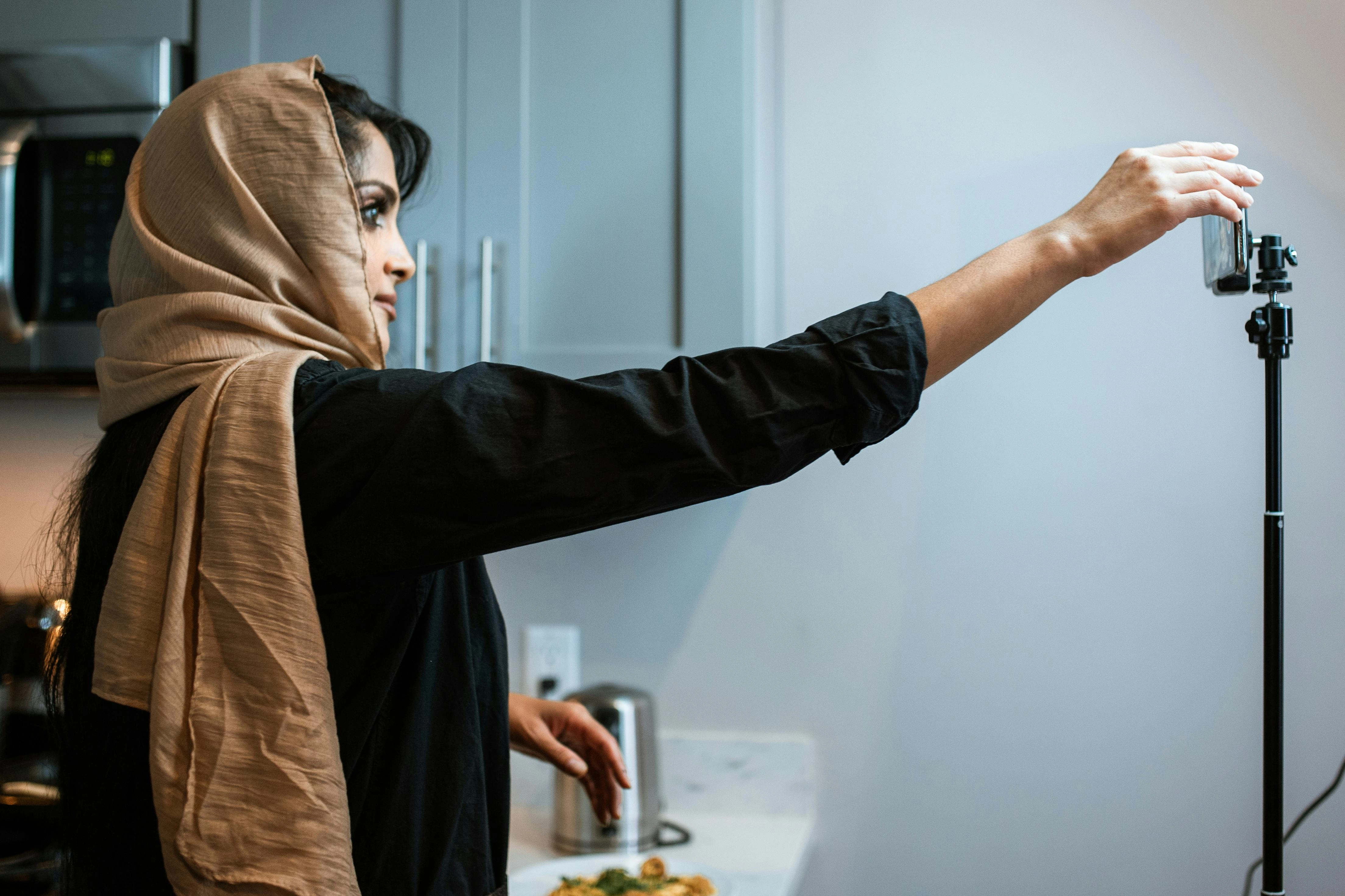 Hijabi influencer adjusting camera Hijabi influencer adjusting camera