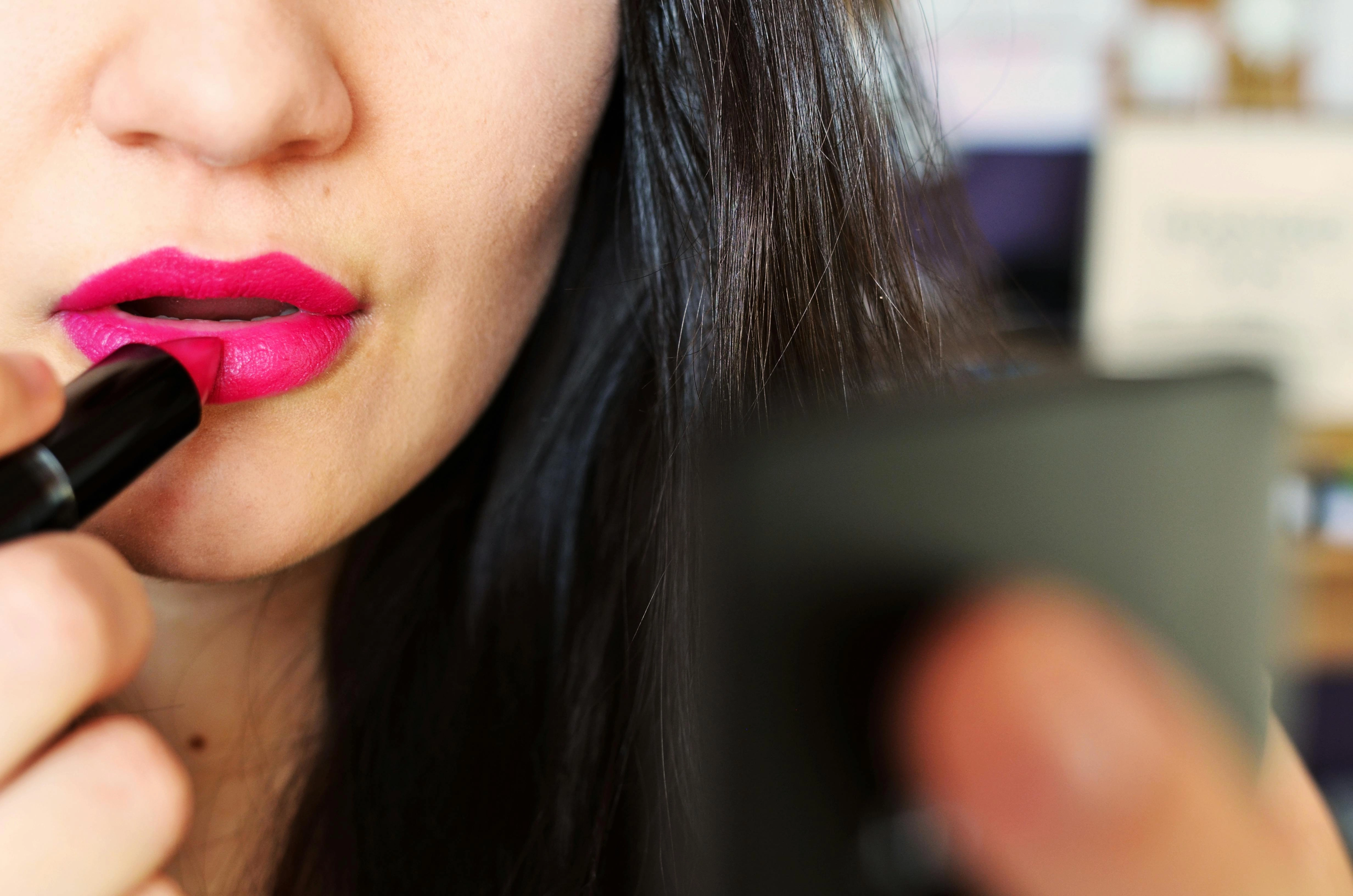 Applying Vibrant Pink Lipstick