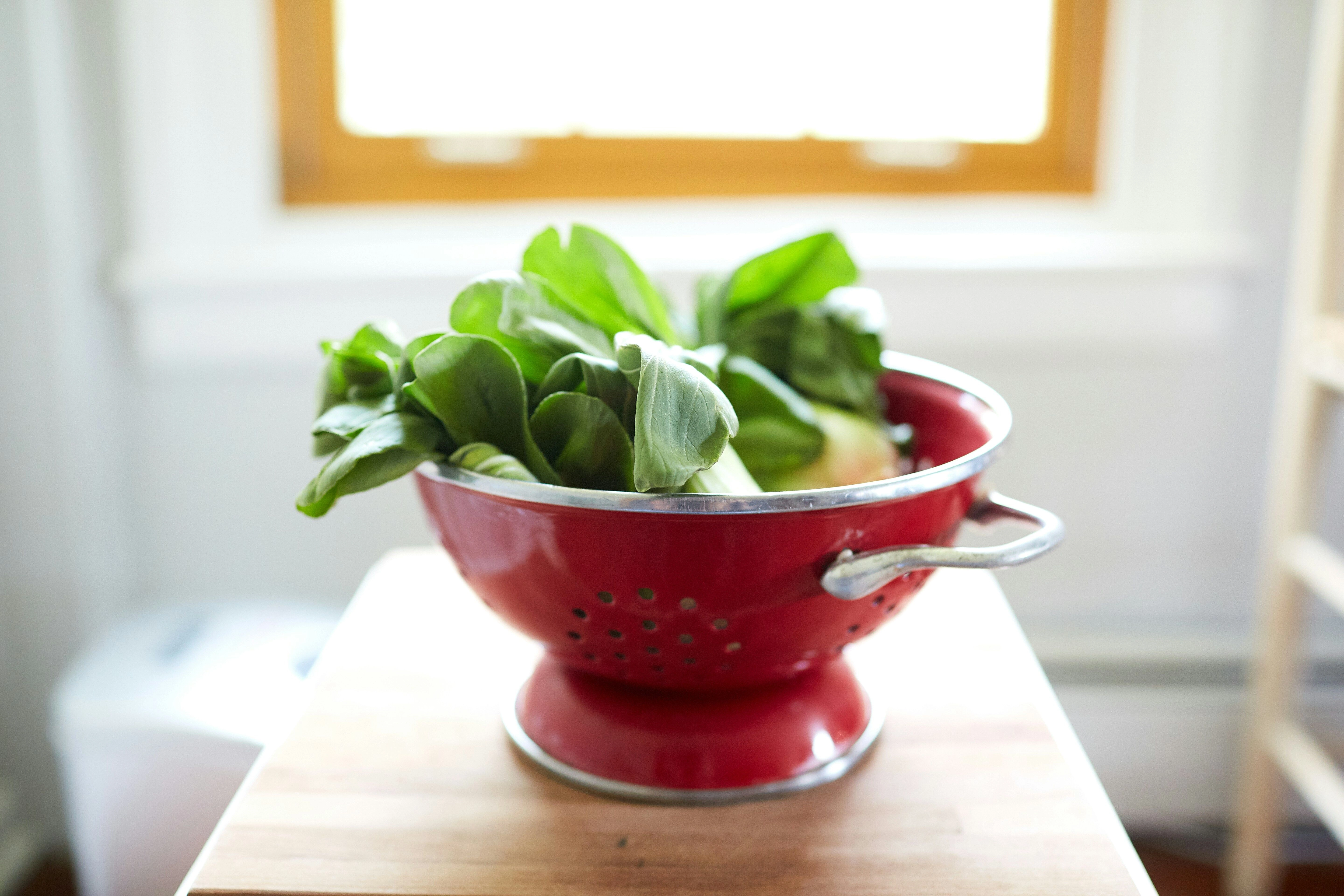 Fresh Greens in Red Colander Fresh Greens in Red Colander